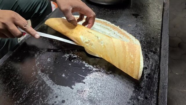 Crispy plain dosa on a hot flat tawa griddle