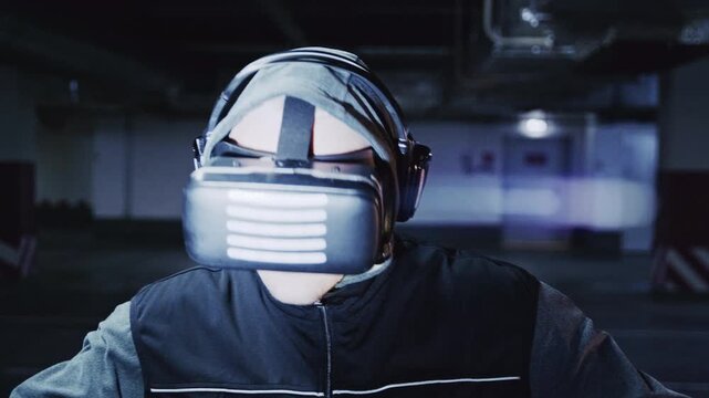 A male user explores a virtual environment while walking at a slow, cautious pace in an empty concrete parking area. His hand movements and shifting gaze reveal deep engagement with the digital space.
