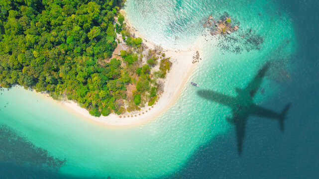 Aerial view of shadow passenger plane silhouette and sandy beach blue sea with waves at sea beach summer vacation sea travel concept	
