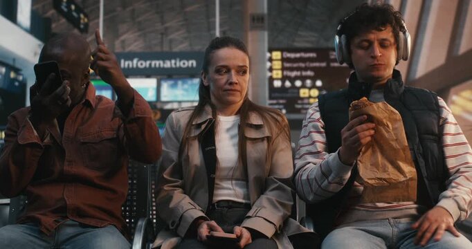 Woman Irritation, Wait For Flight in Loud, Emotional Crowd. Female Keeps Lips Pressed, Stoically Enduring Surrounding Disturbance. Social Friction, Lack of Public Etiquette, and Patience Required.