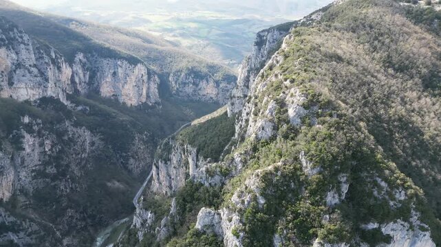 Aerial drone footage over Frasassi Gorge, Italy: rocky cliffs, green vegetation and dramatic natural landscape. Ideal for travel, nature and geological projects.