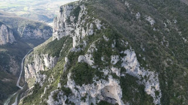 Aerial drone footage over Frasassi Gorge, Italy: rocky cliffs, green vegetation and dramatic natural landscape. Ideal for travel, nature and geological projects.