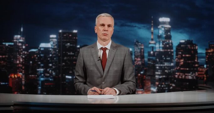 Male Anchor in Grey Suit Hosts Weekly Analytical News Program in Modern Studio. Man Analyzes Key Political and Economic Topics, Providing Expert Commentary and Summarizing Main News For Wide Audience.