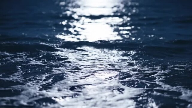 Dark blue ocean water with sunlight reflection.