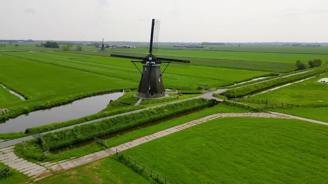 Aerial rotating view of traditional dutch windmill in rural Netherlands.