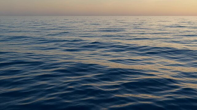 calm ocean waves at sunset over open sea horizon
