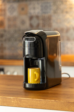 Modern Coffee Machine with Espresso Cup on Wooden Kitchen Counter. In a Cozy Kitchen