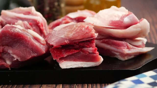 Raw meat cuts displayed on black cutting board ready for cooking delicious fresh dinner meal.