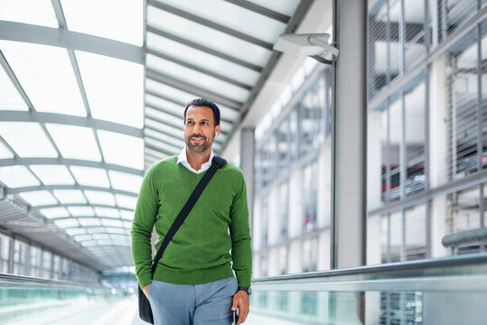 Business professional walking in urban indoor corridor smiling