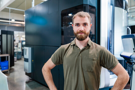 Young man in a production hall with industrial machinery