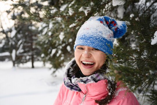 Smiling adult in pink jacket enjoying snowy winter day outdoors