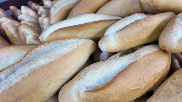 Freshly baked bread rolls arranged in bakery creating inviting display for customers.