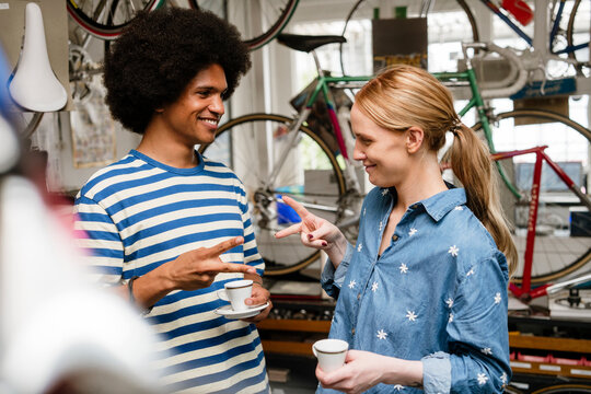 Friends playing rock paper scissors at urban bicycle shop cafe