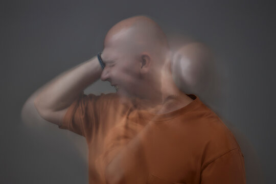 Mature person struggling with anxiety in studio with motion blur