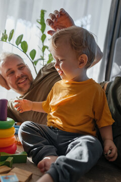 Father and child playing with educational toy indoors together