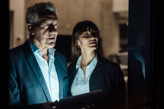 Business team collaborating late in modern office at night