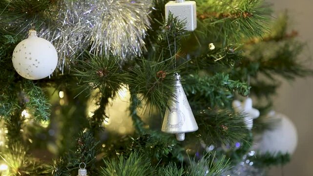 Un sapin de No&euml;l illumin&eacute;, d&eacute;cor&eacute; pour les f&ecirc;tes de fin d'ann&eacute;e. Gros plan sur des d&eacute;coration d'un sapin de no&euml;l artificiel, avec guirlande lumineuse en fond. 
