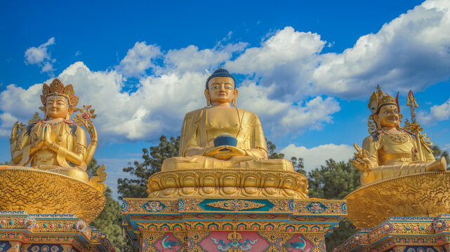 Three Golden Buddha Statues in Kathmandu Park under Blue Sky with Copy Space