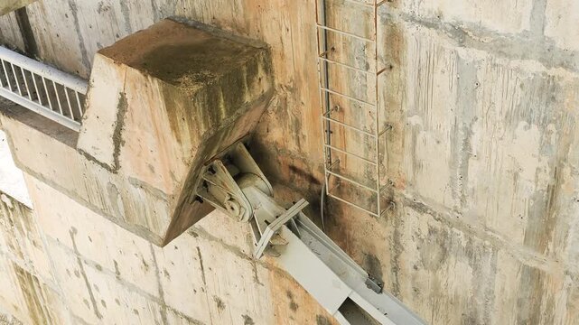 Hydraulic steel and hinge support anchor massive gate to concrete wall. Heavy industrial pivot allows for controlled movement of water barrier. This hydraulic steel component works with hinge support.