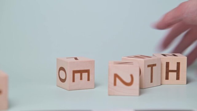 A hand moves wooden letter blocks to form the word growth on a light background. The activity showcases the destruction, aggression emotion