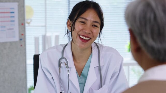 Doctor Reviewing Medical File While Interviewing Elderly Patient at Clinic or Hospital