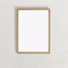 Obraz premium A minimalist wooden frame with a blank white canvas, hanging on a plain light-colored wall.
