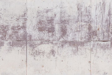 Fototapeta premium Concrete wall with faded paint and rough texture in outdoor daylight