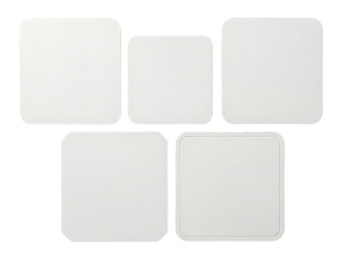 Arrangement of five modern white square coasters with rounded corners, showcasing various textures.