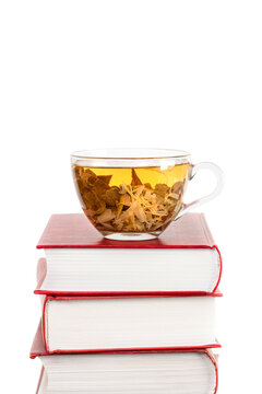 Middle of photo Stack of books with a glass cup of herbal tea on top of it isolated white background space for text copy space vertical macro