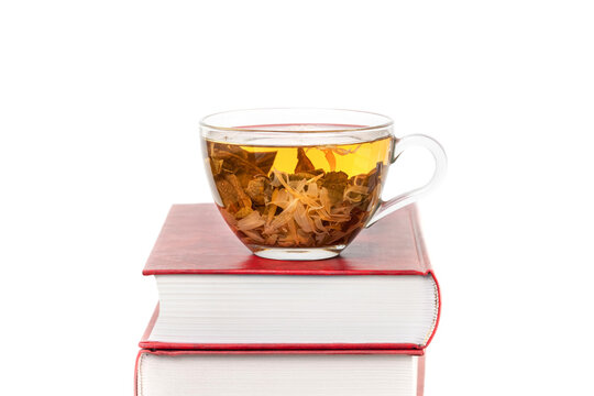 Middle of photo Stack of books with a glass cup of herbal tea on top of it isolated white background space for text copy space macro