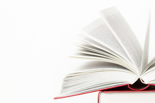Stack of books and one opened book on top front view isolated white background space for text copy space macro