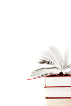 Stack of books and one opened book on top front view isolated white background space for text copy space vertical macro
