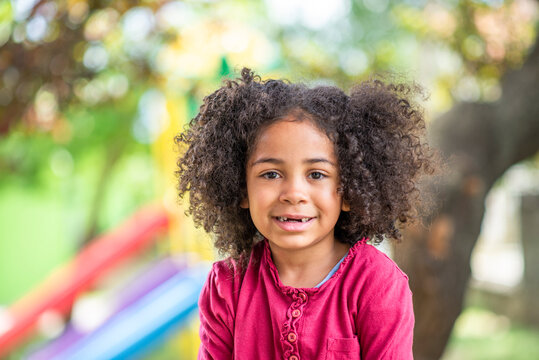 beautufil girl playing outdoors in the playground, sweetheart showing heart made with hands and sending love 
