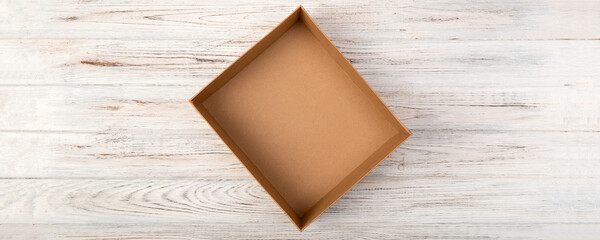 Fototapeta premium Empty Cardboard box on a white wooden background top view