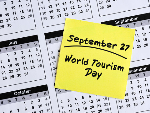 Yellow sticky note reminding world tourism day on september 27 on calendar