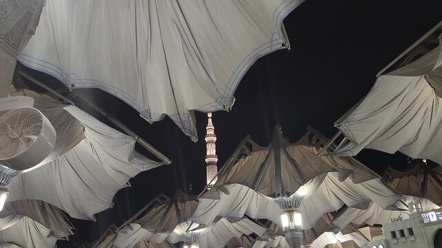 Nabawi mosque tower decorated with umbrellas closed in the night