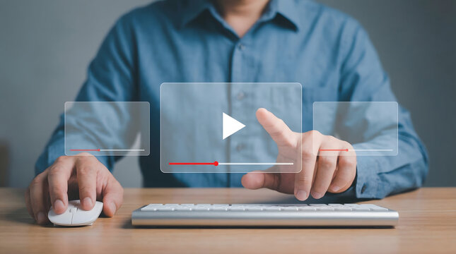 Man interacting with virtual video player interface on a wooden desk using keyboard and mouse