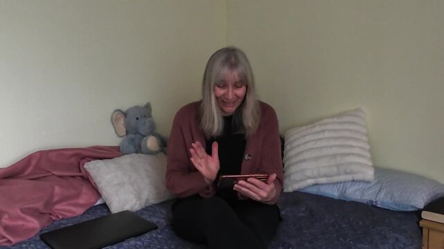 Mature woman chatting on smartphone at home with different emotions