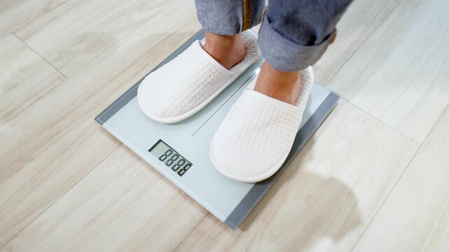 Person in White Slippers Stepping on Digital Bathroom Scale to Check Weight