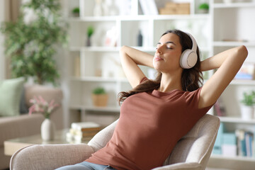 Woman listening music relaxing on armchair at home