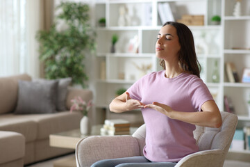 Woman doing breathing exercises on armchair