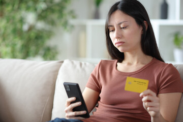 Overwhelmed asian woman buying online at home
