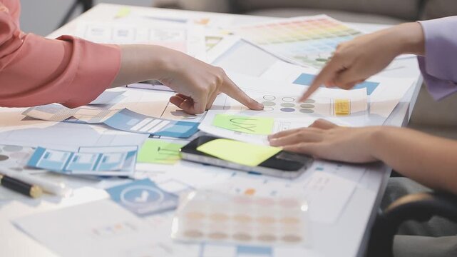 Asian uxui designer working on website design using sticky notes and wireframes