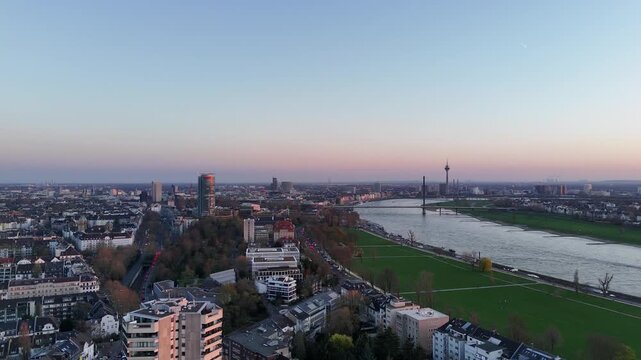 Long drone glide parallel to the Rhine toward the Ergo tower with bridges and skyline parallax.