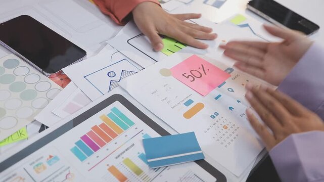 Asian uxui designer working on website design using sticky notes and wireframes