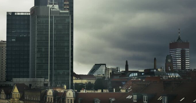 Dynamic hyperlapse of the Poznań skyline in Poland with modern architecture under dramatic clouds. Captures urban energy in panoramic aerial footage, enhancing a brooding atmosphere.