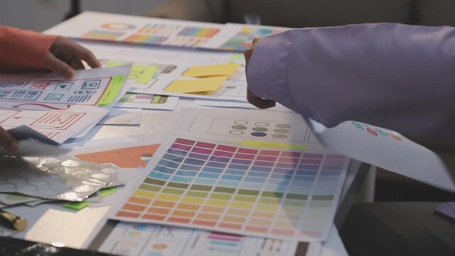 Asian uxui designer working on website design using sticky notes and wireframes