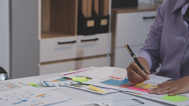 Asian uxui designer working on website design using sticky notes and wireframes