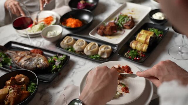 Elegant Woman eating Delicious food at Restaurant Using Knife and Fork. Served Table with Dishes in Rich Luxury Interior