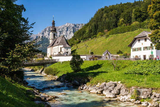 Scenic view of St Sebastian church in Ramsau with Ramsauer Ache river and Bavarian Alps
